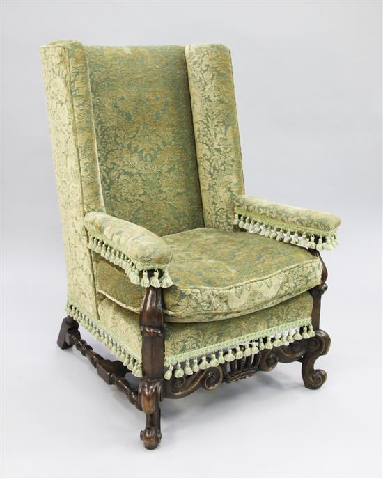 A William & Mary style carved walnut wingback chair,